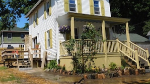 Une maison à deux étages avec un porche et un escalier menant à l’entrée.