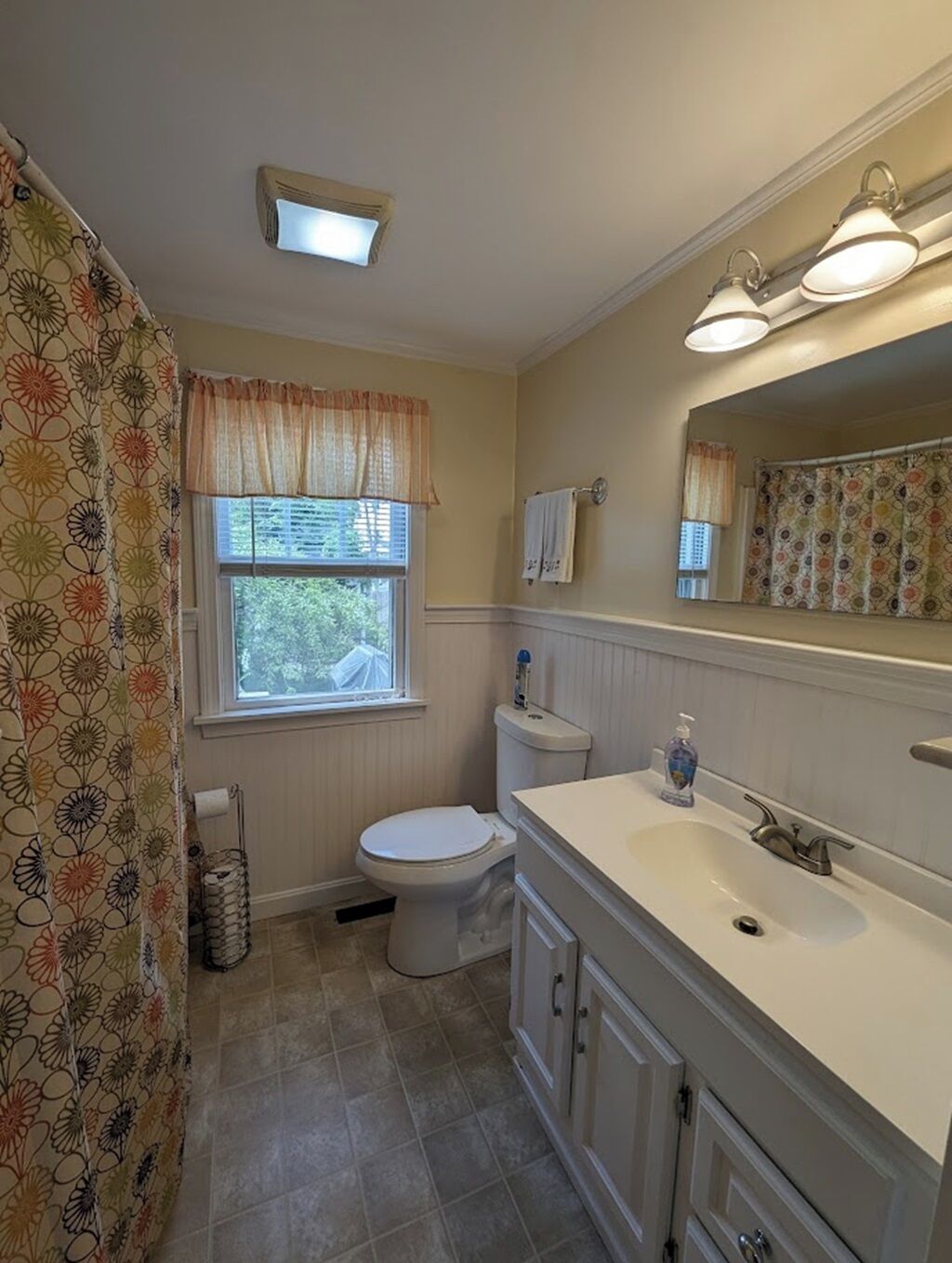 Een badkamer met toilet, wastafel en raam.