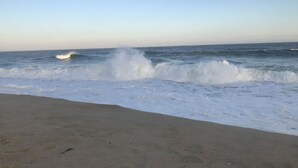 A beach with waves crashing onto the shore.