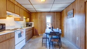 A kitchen with wooden cabinets, a white stove, and a dining table with chairs. - Philip Arthur Suite, Apt #6
Hershey Penthouse overlooking all of Hershey (Hershey)