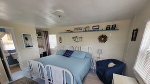 Une chambre à coucher avec un lit, une table de chevet, une lampe et une chaise.