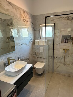 Bathtub, hair dryer, towels, toilet paper