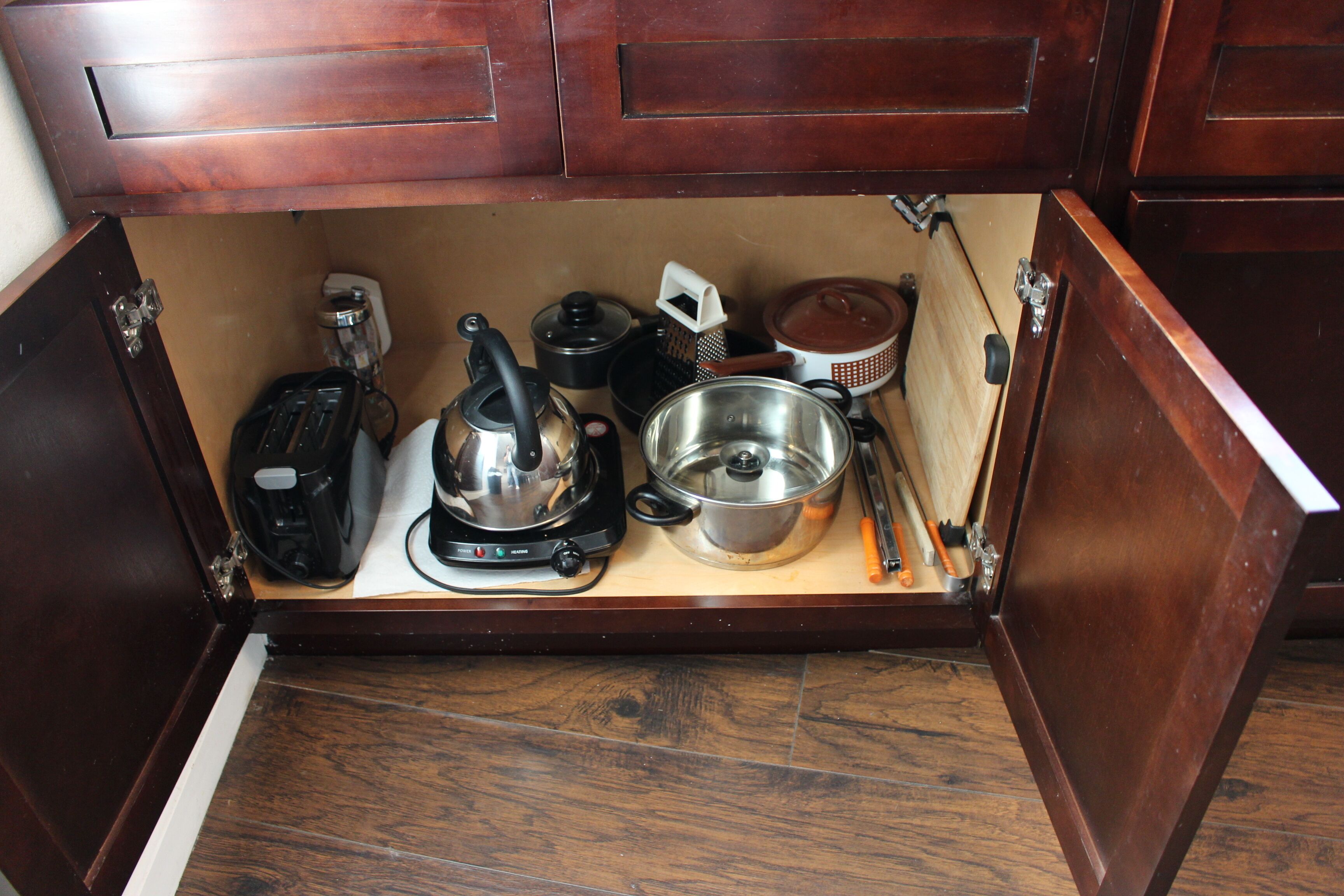 Une cuisine équipée d’une cuisinière intégrée, d’une bouilloire, d’une machine à café et de divers ustensiles.