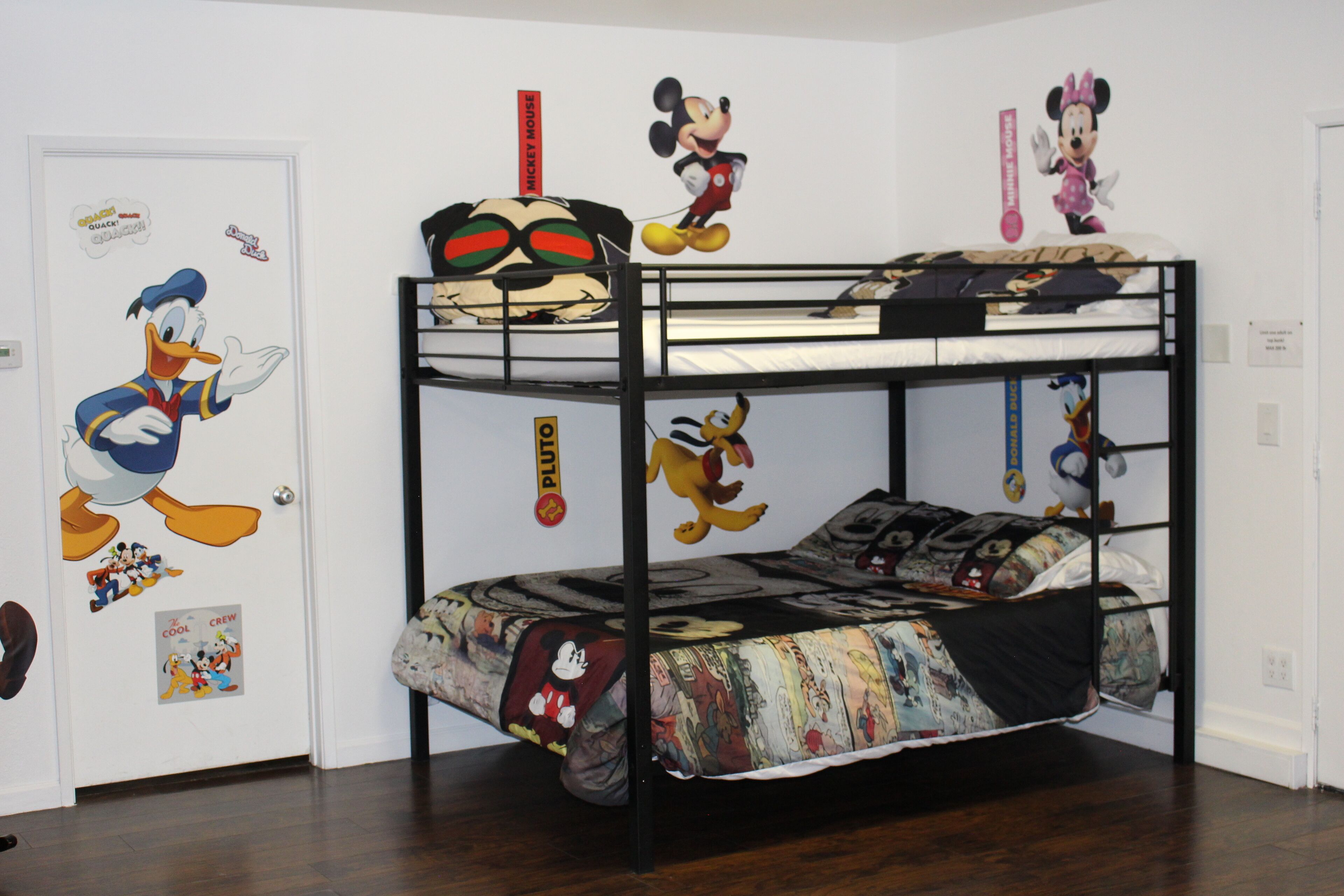 Ein Stockbett mit Disney-Dekoration, darunter Mickey Mouse und Donald Duck.