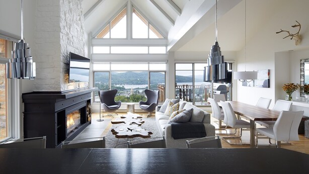 A spacious living room with a fireplace, modern furniture, and large windows offering a view of the outdoors. - White Altitude | Ski-in/Ski-out Mont-Tremblant | Walk to ski village/Views / Hot tub (Mont-Tremblant)