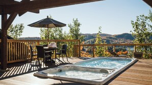 A wooden deck with a hot tub, outdoor seating, and a view of mountains. - White Altitude | Ski-in/Ski-out Mont-Tremblant | Walk to ski village/Views / Hot tub (Mont-Tremblant)