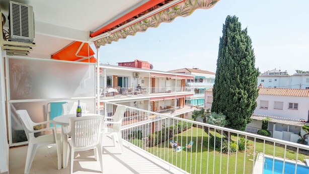 A balcony with a pool, white chairs, and a table. - Sitges with pool near beach by Hello Homes Sitges (Sitges)