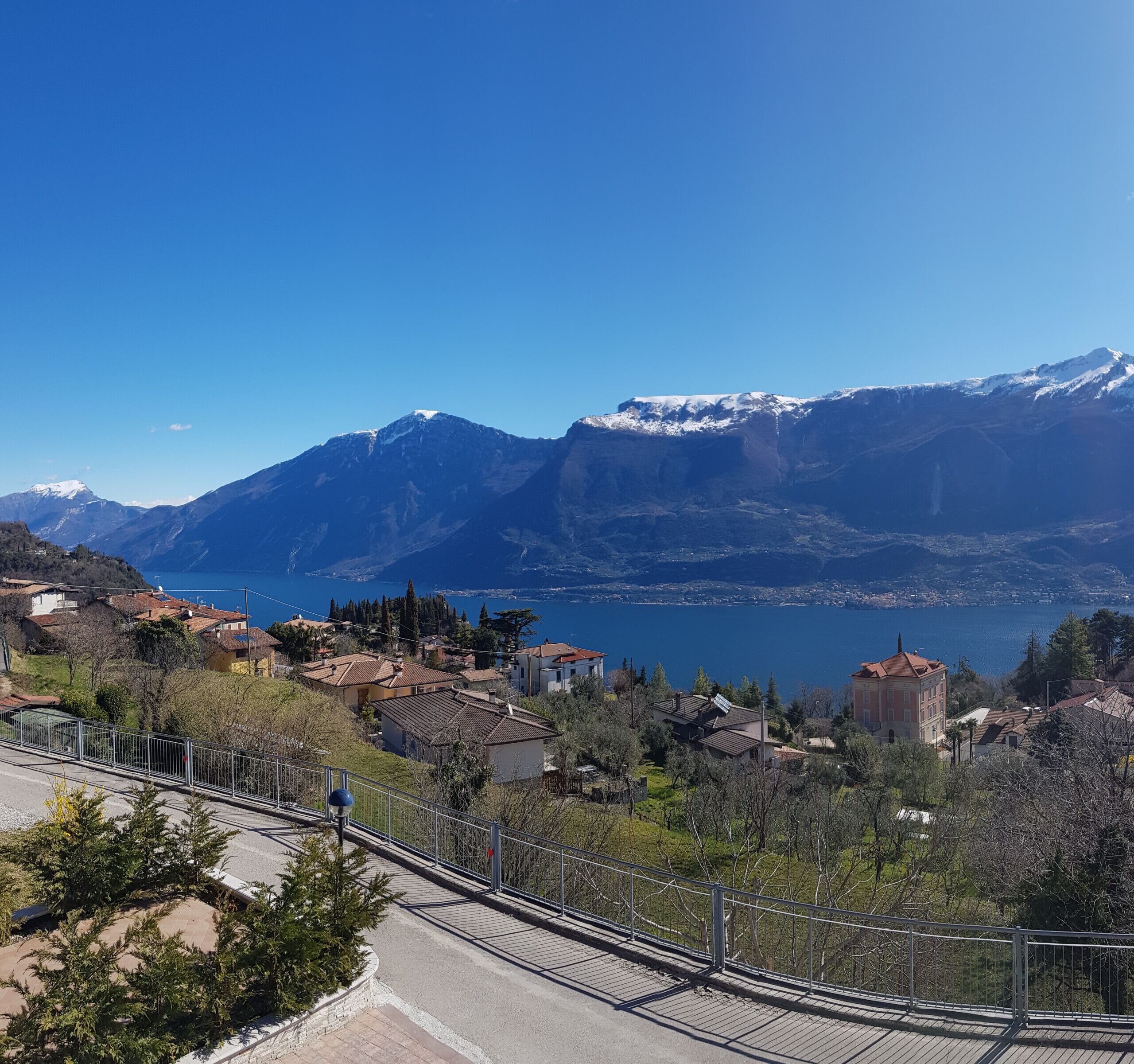 A scenic view of a mountainous area with a lake and residential buildings.