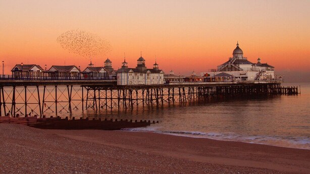 A pier with a large building with a dome and multiple smaller structures.