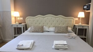 Una cama bien hecha con dos lámparas de noche y un dispositivo de seguridad instalado en la pared.