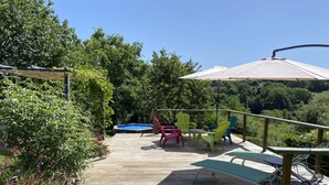 A wooden deck with a pool, outdoor furniture, and a view of the surrounding greenery. - 2 Bedroom & 2 Bathroom Gîte Cottage Heated Plunge Pool & Private Garden 86150 (Le Vigeant)