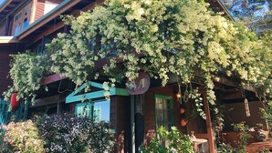A wooden house with a balcony covered in flowering vines. - The Goat and Goose B&B (Lakes Entrance)