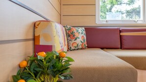 Un coin salon confortable avec un banc rembourré et un coussin décoratif.