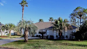 A residential house with a well-maintained lawn, palm trees, and a clear blue sky. - Jacksonville Vacation (Jacksonville)