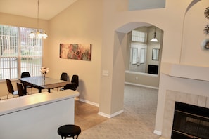 A dining area with a table and chairs, a vase with flowers, and a painting on the wall. - Jacksonville Vacation (Jacksonville)