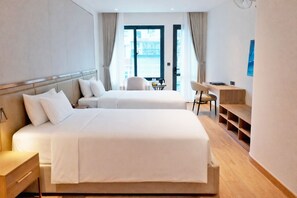 A hotel room with two beds, a desk, a chair, and a view of the city. - A25 Hotel -  96 Hai Ba Trung (Hanoi)