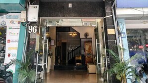 The entrance of A25 Hotel with a red sign, glass doors, and a red carpet leading inside.