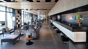 A modern lobby with a reception desk, seating areas, and large windows. - DoubleTree by Hilton Tokyo Ariake (Tokyo)