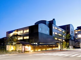 A modern building with multiple floors, large windows, and a curved architectural design.