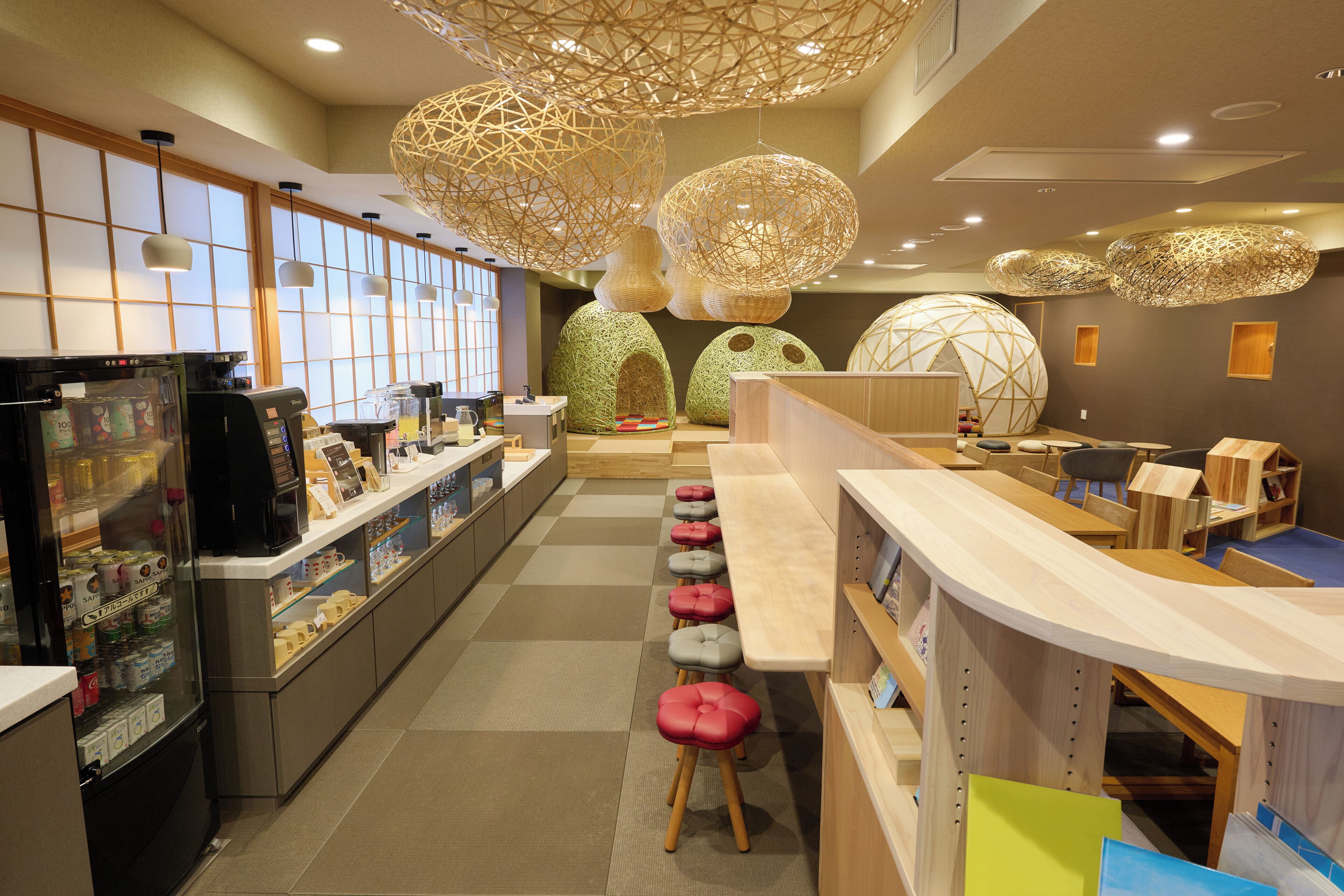 A modern interior with a long counter, stools, and decorative spherical light fixtures.
