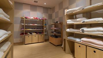 A hotel room with wooden shelves and cabinets, organized with neatly folded towels and clothing.