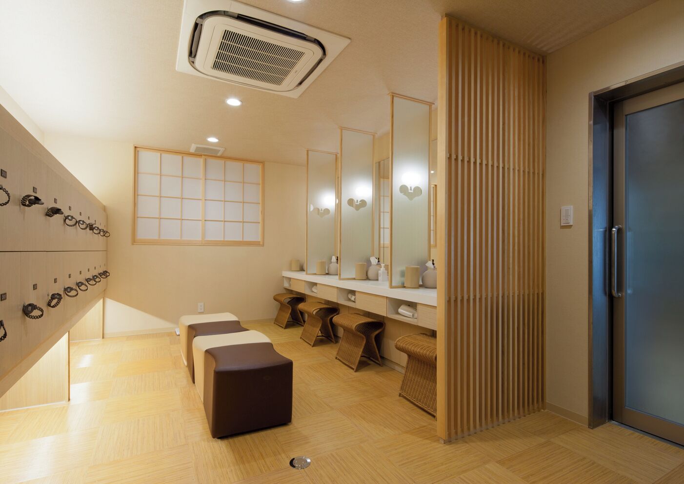 A modern bathroom with a wooden floor, a large mirror, and a towel rack.
