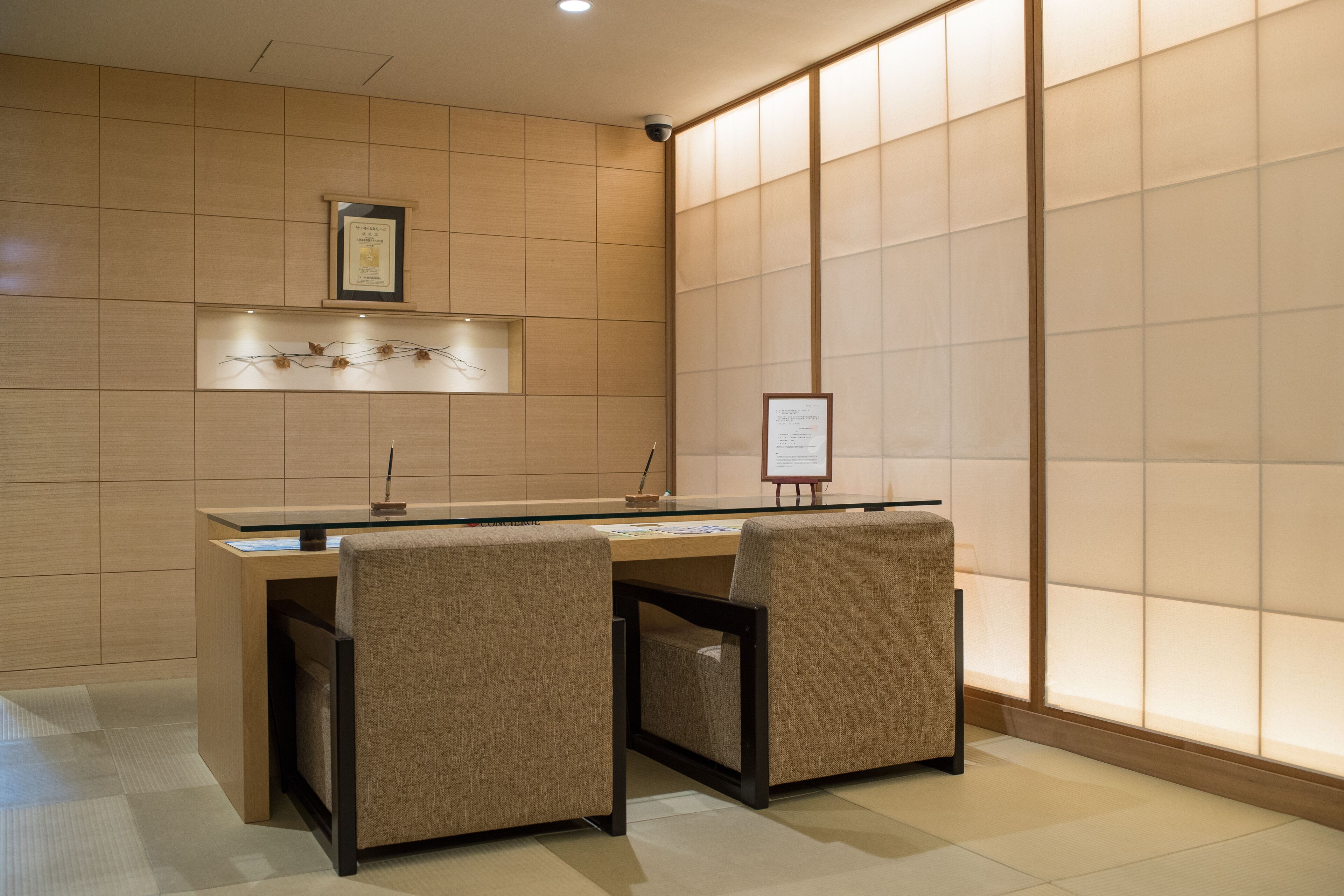 A reception desk with two chairs, a framed certificate on the wall, and a bulletin board.