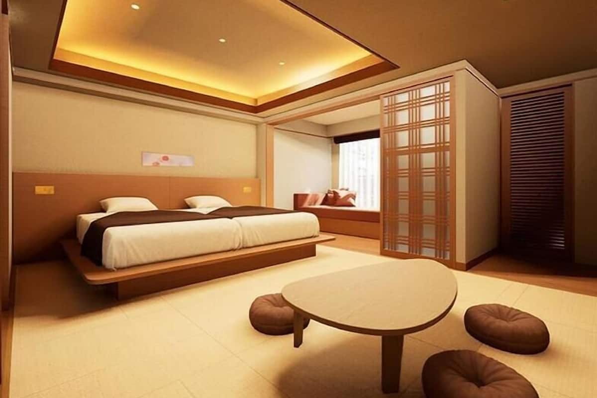 A modern bedroom with a large bed, a small round table, and a traditional sliding door.