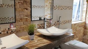 A bathroom with two sinks, a toilet, and a shower.