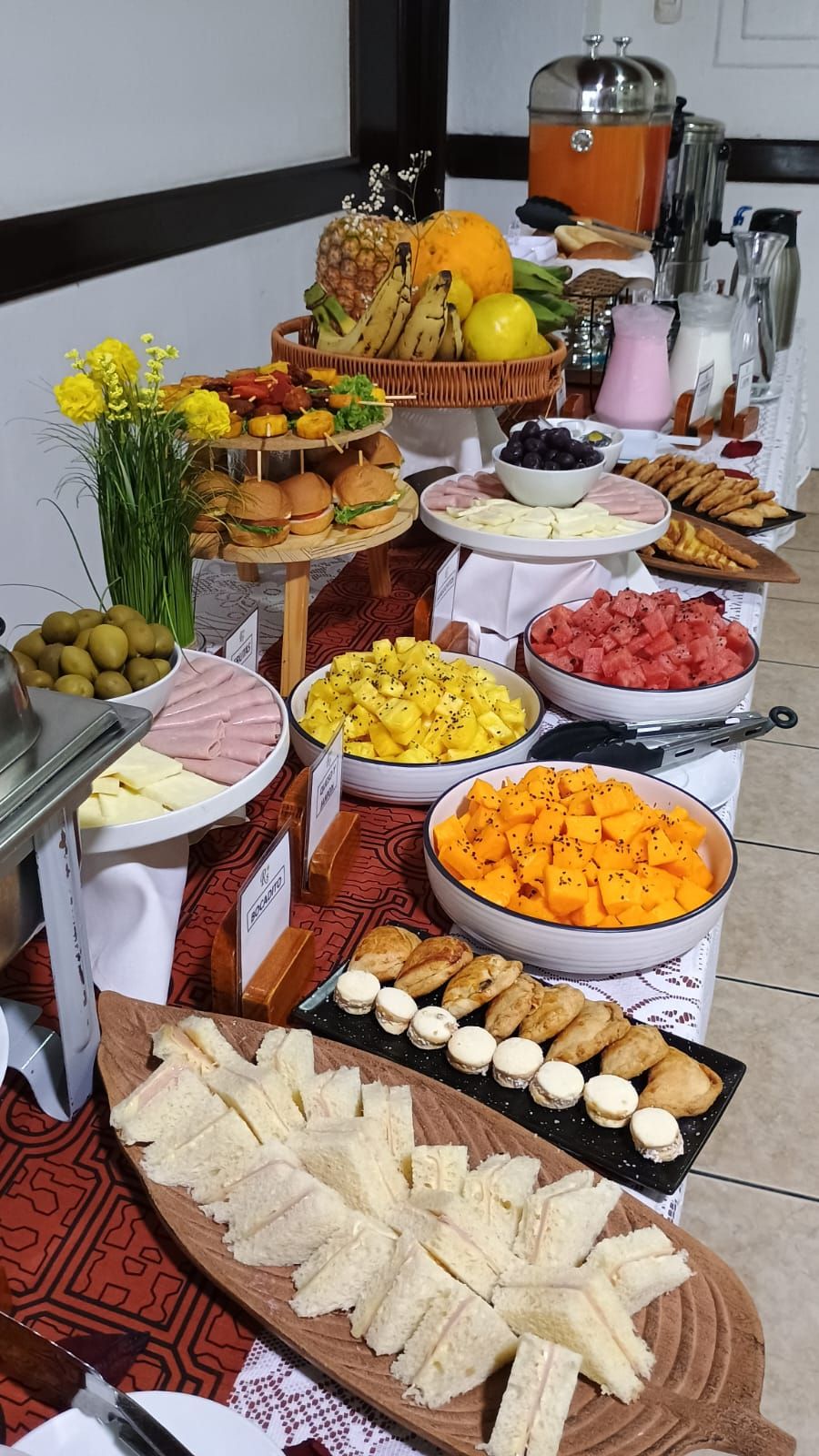A buffet with various food items including fruits, cheeses, and pastries.