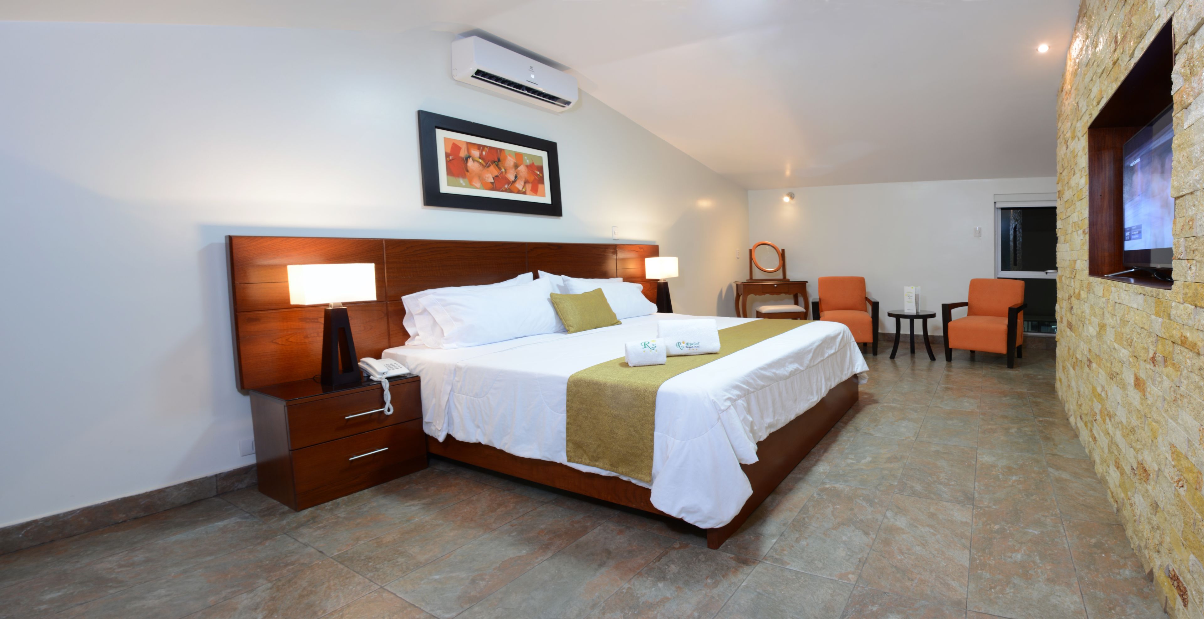 Une chambre d’hôtel avec un grand lit, des tables de chevet, un bureau et une chaise.