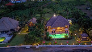A resort with multiple thatched-roof buildings, a swimming pool, and well-lit outdoor areas. - 5 * Lovina Beachfront pool villa Free Dolphin Tour (Dencarik)