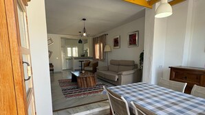 A dining area with a checkered tablecloth, a wooden bench, and a modern pendant light. - The Blue Pearl, a dream terrace in the sun (Roquetas de Mar)