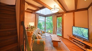 A cozy living room with a wooden bench, a sofa, and a television. - One More Time Heart (Nikko)
