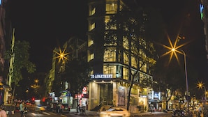 Un edificio de varios pisos con un cartel llamativo que dice 'APARTMENT' en la entrada.