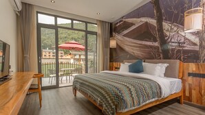 A hotel room with a large bed, wooden headboard, and a view of a building through a glass door. - Purmei Hotel Lugu Lake (Lijiang)