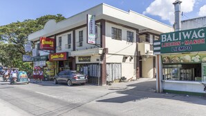 A building with a Pension Inn sign, a Balwag restaurant, and a car parked in front. - Pension Inn Marilao (Marilao)