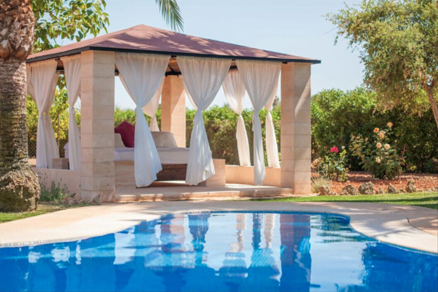 Un belvédère avec une piscine au premier plan.
