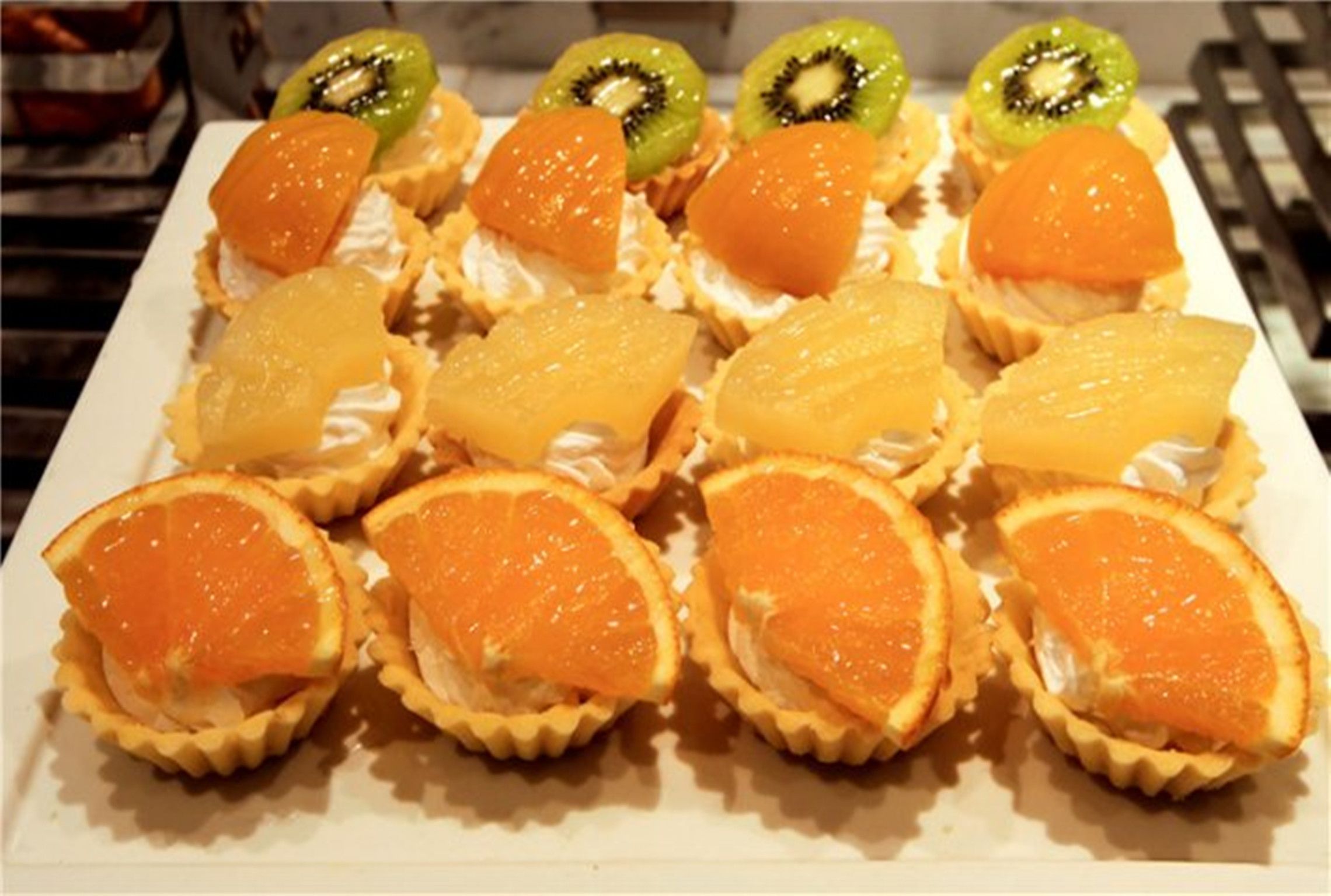 A dessert tray with various fruit tarts.