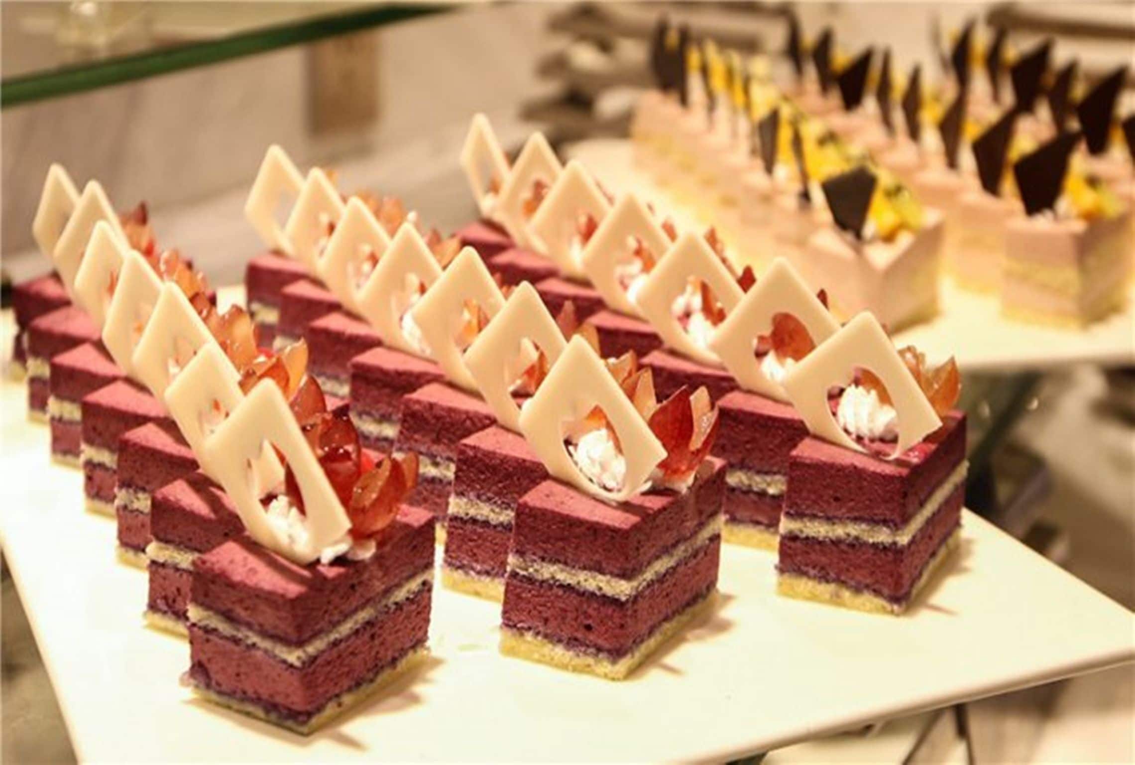 A display of layered desserts with white chocolate decorations.