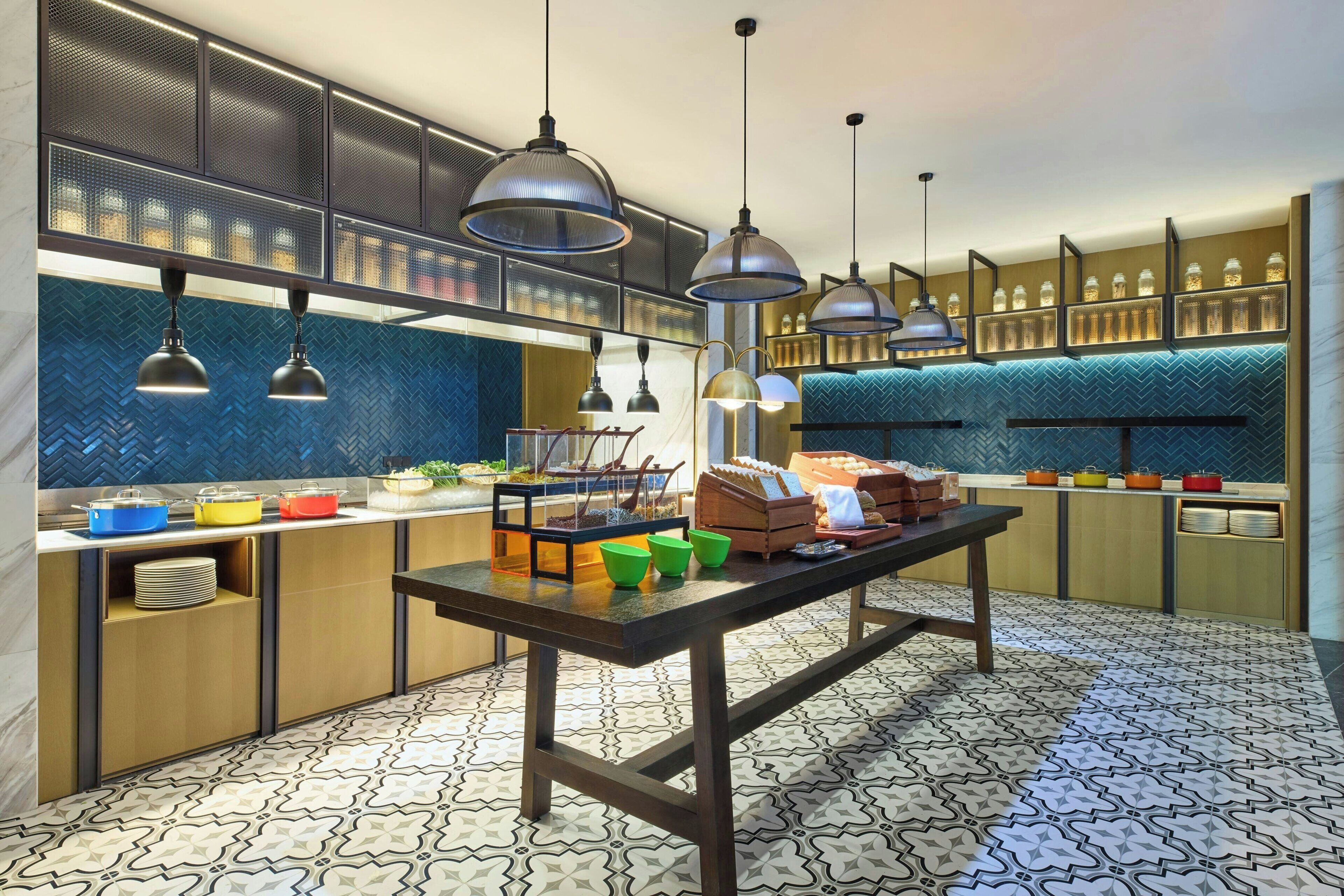 A modern kitchen with pendant lighting, a central island, and a herringbone-patterned backsplash.
