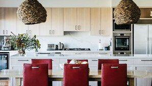 Une cuisine moderne avec des meubles en bois, un îlot central et des chaises rouges.