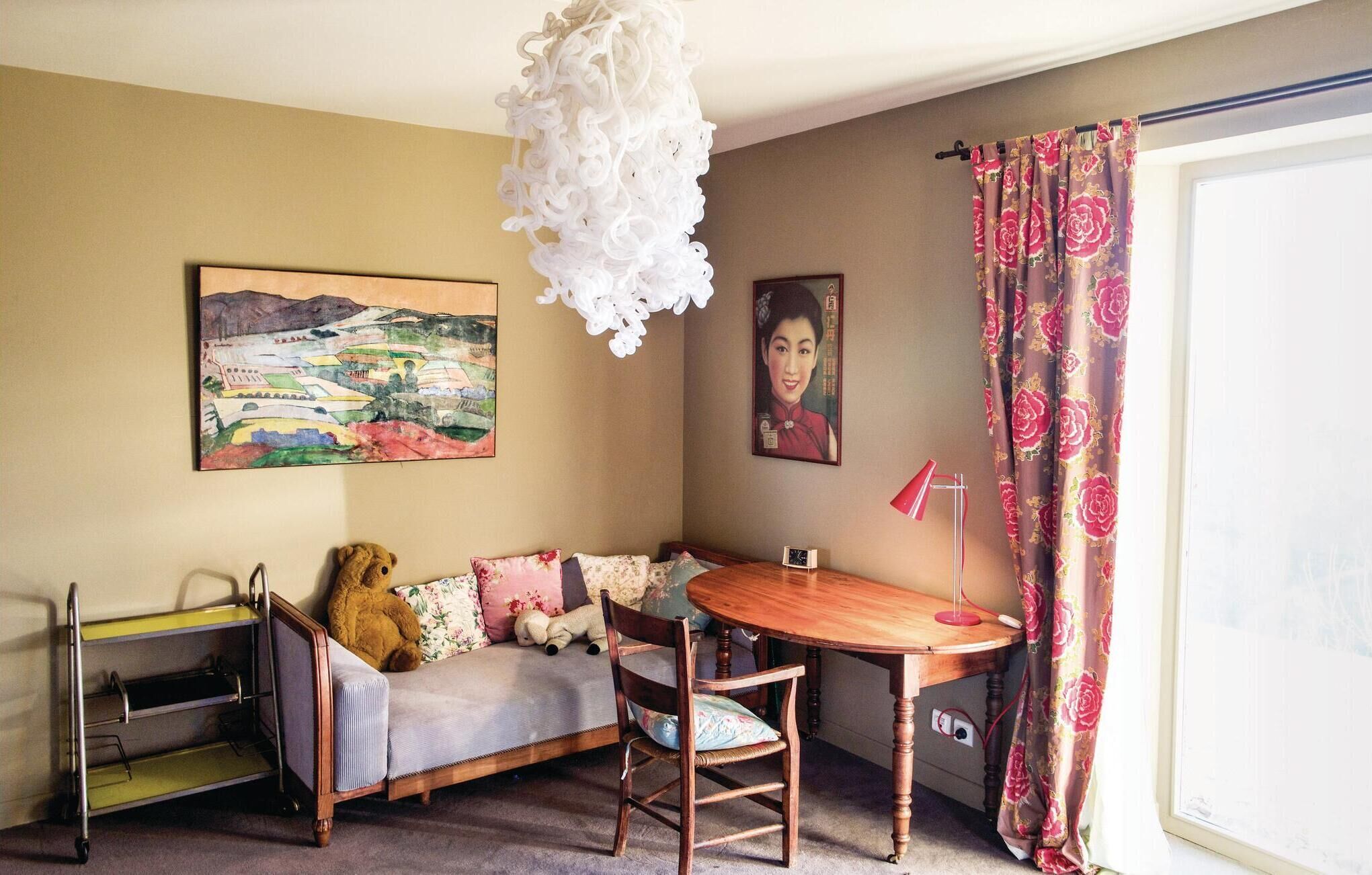 A cozy room with a sofa, a small table, a teddy bear, and a lamp.