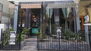 A building with a storefront, a gated entrance, and a staircase leading to the entrance. - AO Apartment (Vientiane)
