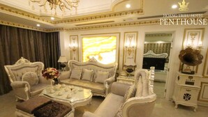 A luxurious penthouse suite with ornate furniture, a large window with a view, and a chandelier. - Hoang Trieu Hotel (Ho Chi Minh City)