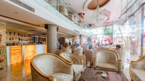 A spacious lobby with high ceilings, a chandelier, and seating areas. - Hoang Trieu Hotel (Ho Chi Minh City)