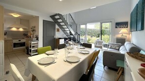 A modern kitchen with a dining area, a staircase, and a view of the outdoors. - 3-bedroom vacation home with heated pool 6 beds (L'Aiguillon-sur-Vie)