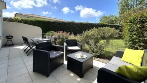 An outdoor patio with wicker furniture, a table, and a grill. - 3-bedroom vacation home with heated pool 6 beds (L'Aiguillon-sur-Vie)