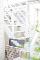 A staircase leading to a house with a sign reading "Zushi Beach House".