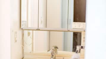 A bathroom with a white sink, a mirror above it, and a towel hanging on the right.